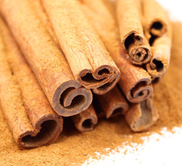 Cinnamon powder and sicks isolated on white
