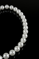 pearl necklace on a dark background with reflection