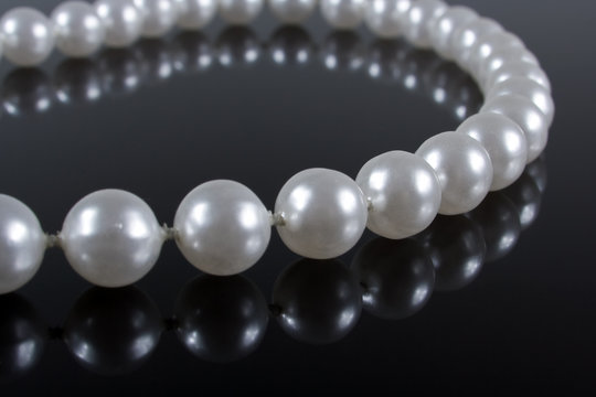 pearl necklace on a dark background with reflection