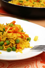 teller goldgelber reis mit mild gewürzter gemüsemischung
