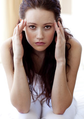 Naklejka premium Brunette woman having a headache in bed