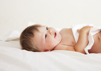 Baby lying on white sheet