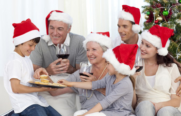 Fototapeta premium Family drinking wine and eating sweets in Christmas