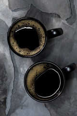 Fototapeta na wymiar black coffee in black cups on gray stone background
