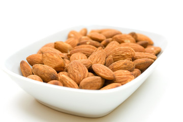 Almonds in bowl over white background
