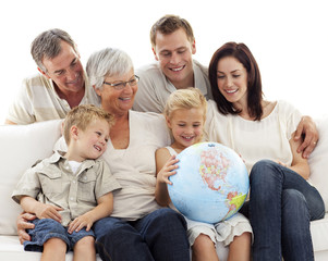 Fototapeta na wymiar Big family on sofa looking at a terrestrial globe