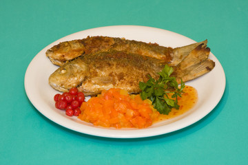 Fried fish in plate on a green background