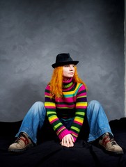 red-haired girl sits in a hat