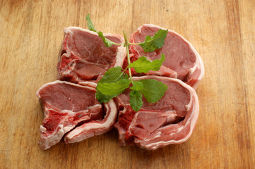 organic raw lamb chops on a timber board