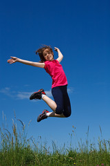 Girl  running, jumping against blue sky