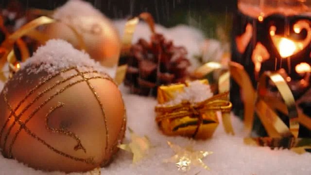 Goldene Christbaumkugeln mit Schneefall