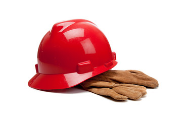 Red hard hat and leather work gloves on white