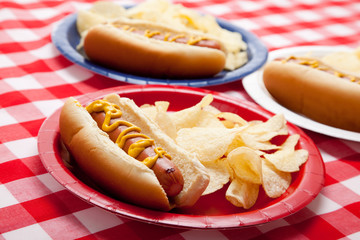 Several hotdogs on colored plates