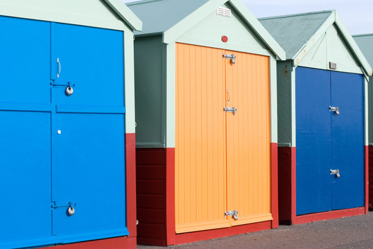 Row of colourful beach huts in Brighton UK