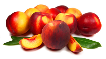 Peaches with slices and leaves isolated on white