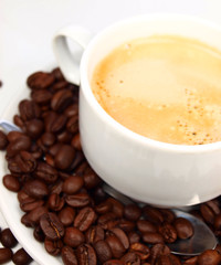 Cup of coffee with coffee beans isolated on white