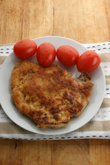 cutlet with organic tomato on a white plate