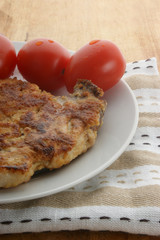 cutlet with organic tomato on a white plate
