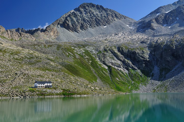 Naklejka na ściany i meble Alpine lake and mountain hut