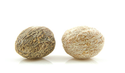 Two fresh nutmeg over white background