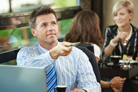 Businessman Paying In Cafe