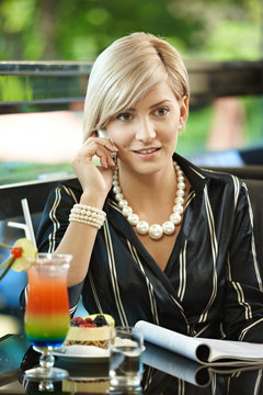 Businesswoman talking on mobile in cafe