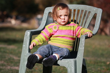 bébé file de 15 mois assise sur une chaise