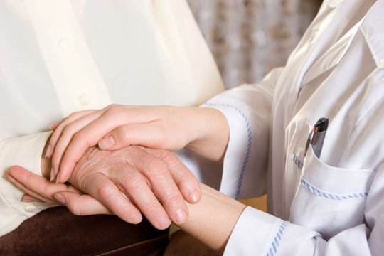 Caring hands of a nurse and elderly woman