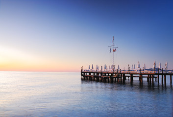 Pier lighted by sunrise glowing