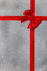 Red ribbon over silver paper with white stars