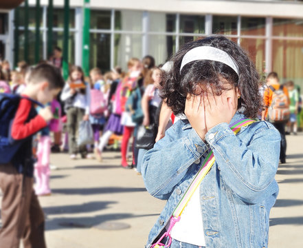 Sad girl  in front of the school, outdoor, summer to fall