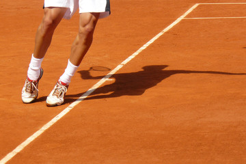 Athletic pose of a tennis player serving showing only feet