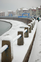 white snow coverd the guardrail of seaside