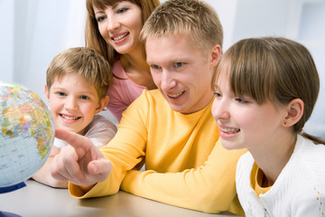 Obraz premium Family examining a globe