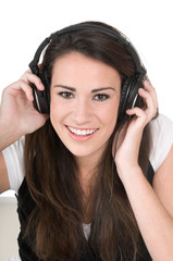 Fototapeta premium Young woman listening to music on headphones, isolated on white