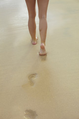 Frau hinterlässt Fußspuren im Sand