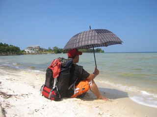 a man with a rucksack holds an umbrella