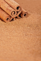 Cinnamon sticks over cinnamon powder with copy-space.