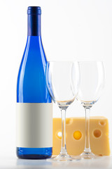 Blue bottle of white wine, two wine glasses and cheese