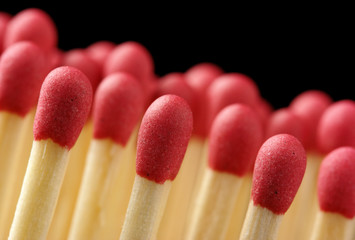 Line of red matchsticks on black background