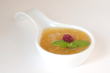 Sweet peach sauce decorated with raspberry and mint