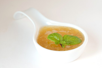 Sweet peach sauce decorated with raspberry and mint