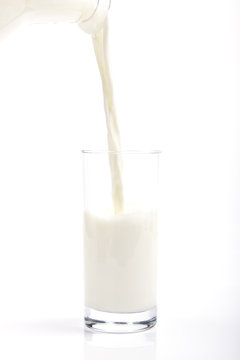 A clean and minimalistic image featuring a glass and pitcher of fresh milk against a white background, evoking purity and health.