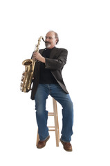 Playing a tenor sax seated on a stool
