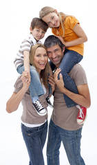 Fototapeta premium Mother and father giving children piggyback ride