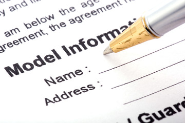 Detail view of the signature box of a contract with a pen.