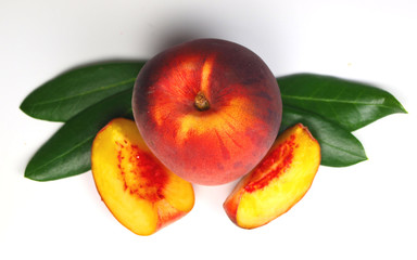 Peach with slices and leaves isolated on white