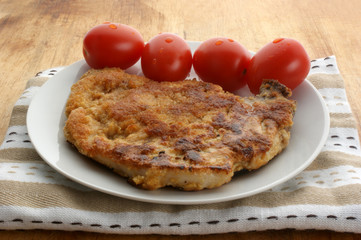 cutlet with organic tomato on a white plate