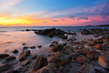 Tropical sunset on the stones beach. Lanta island. Thailand