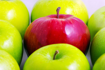 Background of green apples with one red apple